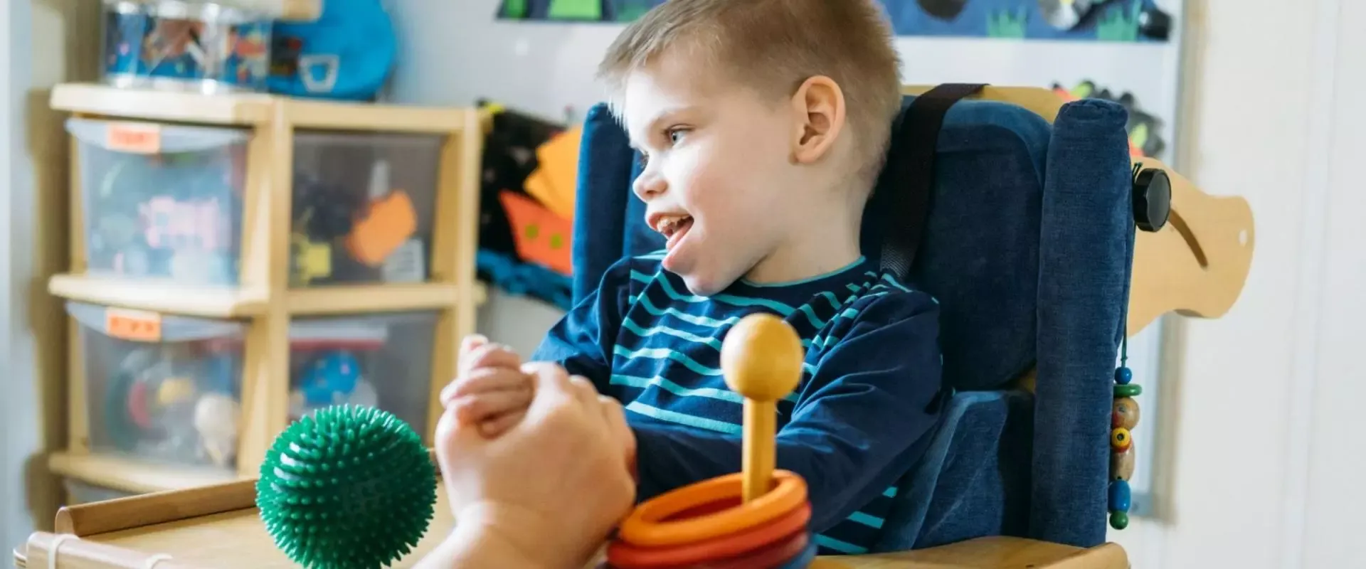 Kind im Rollstuhl bei der Ergotherapie