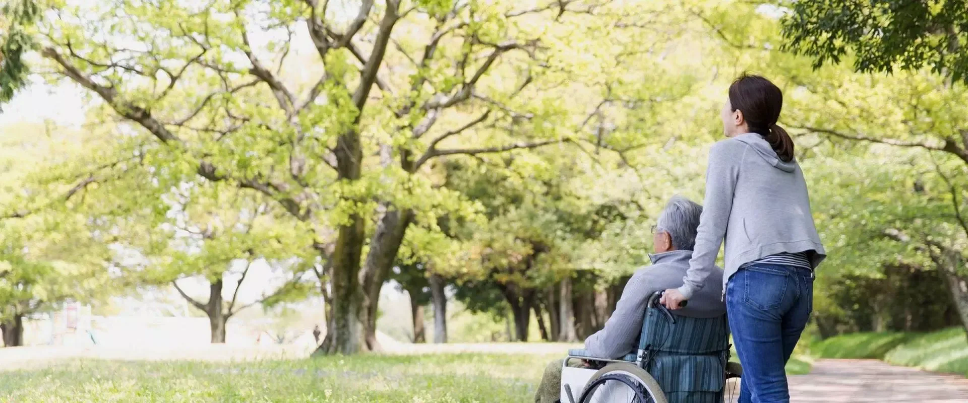 Bild: Frau schiebt Mann im Rollstuhl