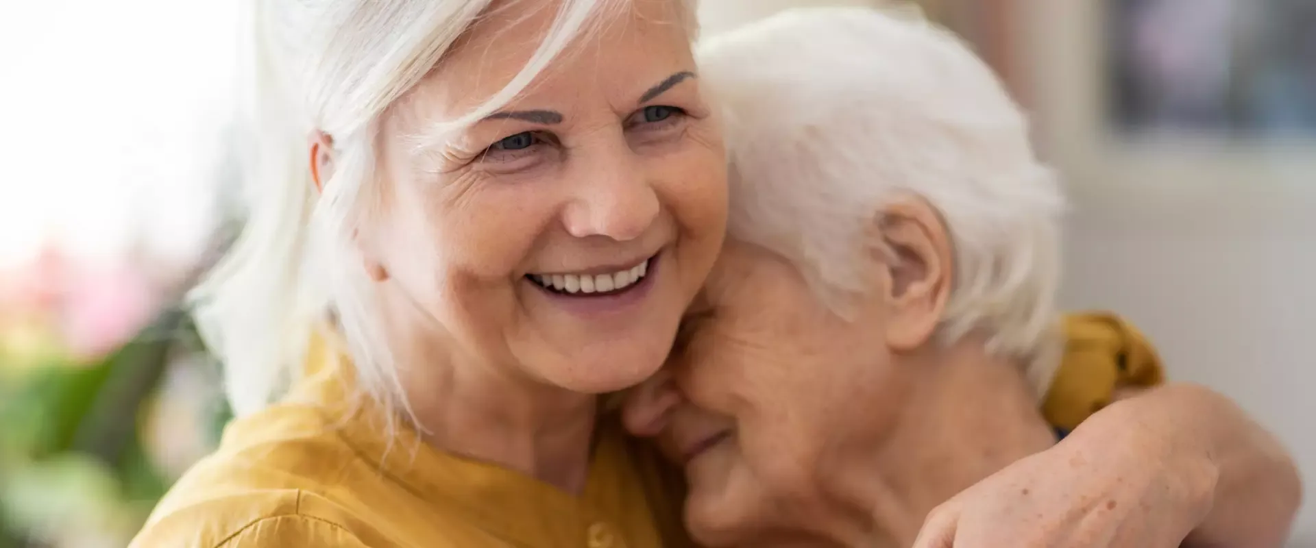 Bild: Frau umarmt Seniorin