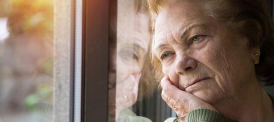 Bild einer depressiven Frau am Fenster