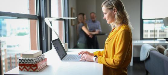 Frau steht am Laptop